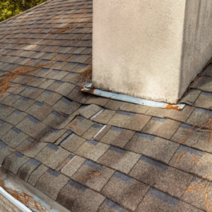 Brown shingles rippling from water damage to roof